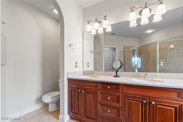 bathroom with vanity, a shower with door, tile patterned flooring, and toilet