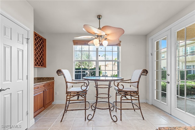 tiled dining room featuring ceiling fan and a healthy amount of sunlight