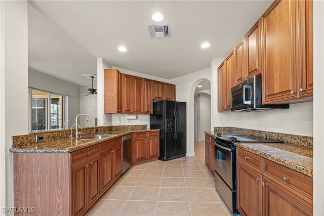 kitchen featuring light tile patterned flooring, sink, black appliances, dark stone counters, and ceiling fan