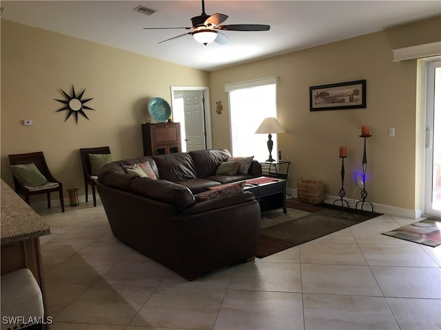 living room with a wealth of natural light, lofted ceiling, ceiling fan, and light tile patterned flooring