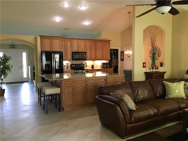 kitchen featuring stone countertops, sink, black appliances, ceiling fan, and vaulted ceiling