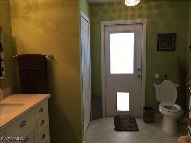 bathroom with toilet, vanity, and tile patterned floors