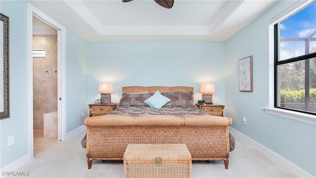 carpeted bedroom with ceiling fan, connected bathroom, and a raised ceiling