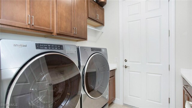 7788 Winding Cypress Dr, Naples, FL 34114 - laundry area with cabinet space and washing machine and clothes dryer