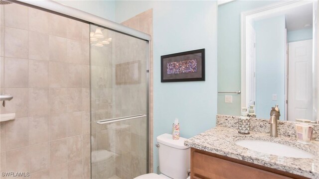 7788 Winding Cypress Dr, Naples, FL 34114 - bathroom featuring vanity, a stall shower, and toilet