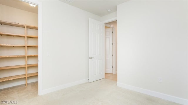 unfurnished bedroom with light carpet and a closet