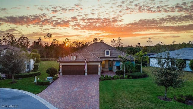 view of front of property with a garage and a yard