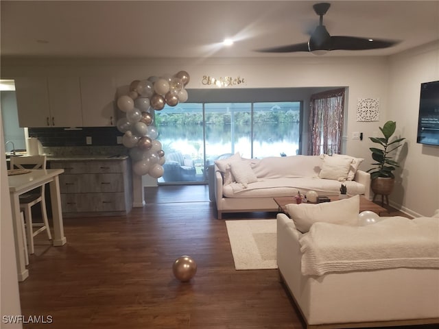 living room featuring ceiling fan and dark hardwood / wood-style flooring