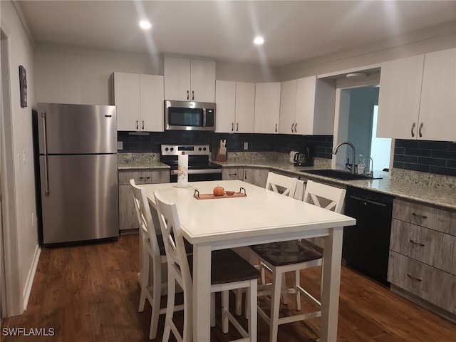 kitchen with white cabinetry, stainless steel appliances, and dark hardwood / wood-style flooring