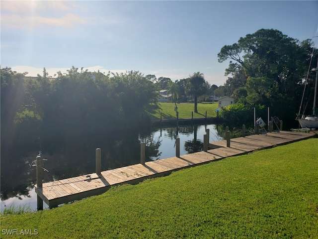 dock area featuring a water view and a lawn