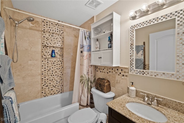 full bathroom with shower / bath combination with curtain, a textured ceiling, vanity, toilet, and tile walls