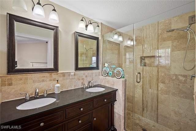 bathroom with vanity, tile walls, a textured ceiling, and a shower with shower door