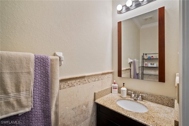 bathroom featuring vanity, tile walls, and ornamental molding