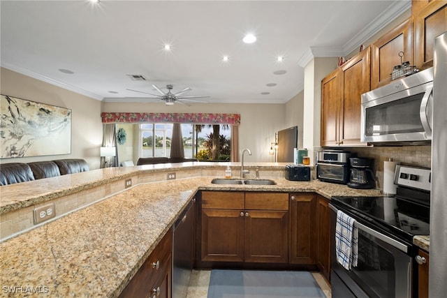 kitchen with kitchen peninsula, appliances with stainless steel finishes, sink, and ornamental molding