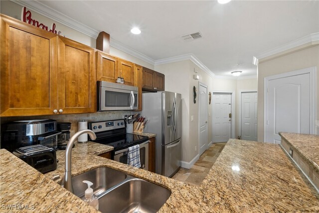 kitchen featuring stainless steel appliances, light stone counters, sink, ornamental molding, and backsplash