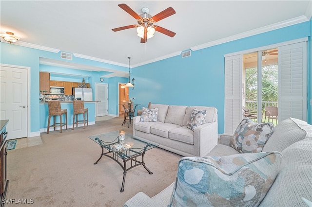 carpeted living room featuring ceiling fan and crown molding