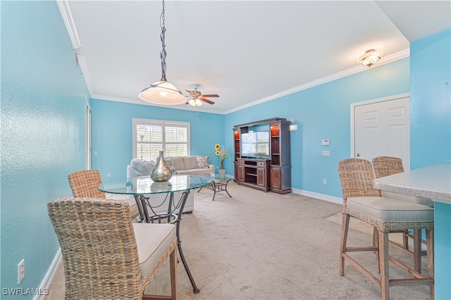 carpeted dining area featuring ceiling fan and crown molding