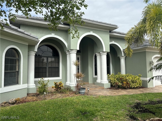 property entrance with a lawn