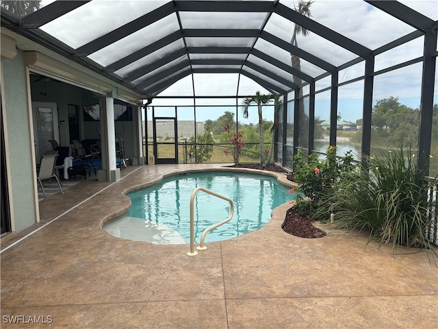 view of swimming pool featuring a lanai, a water view, and a patio area