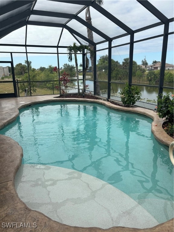 view of swimming pool featuring a water view, glass enclosure, and a patio area