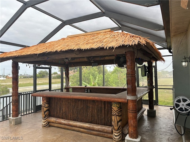 view of patio featuring glass enclosure and a gazebo