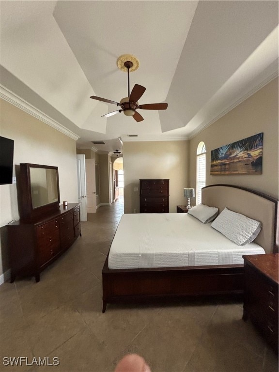 bedroom with dark tile patterned flooring, a raised ceiling, ceiling fan, and crown molding