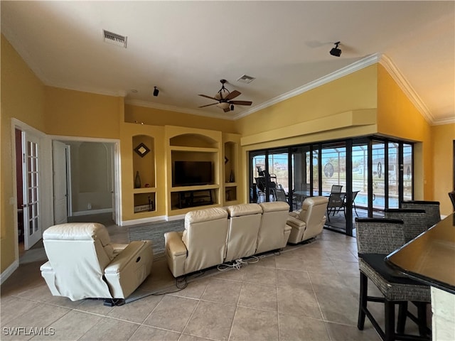 tiled living room with ceiling fan, crown molding, built in features, and french doors