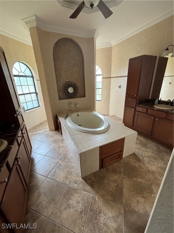 bathroom featuring a wealth of natural light, vanity, crown molding, and tiled tub