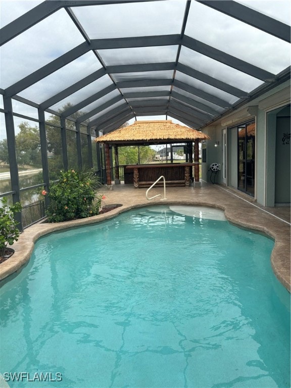 view of swimming pool featuring a lanai, a patio, and a bar