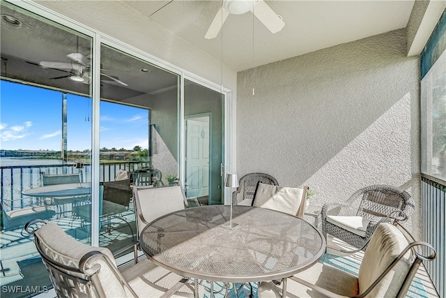 sunroom / solarium featuring ceiling fan and a water view