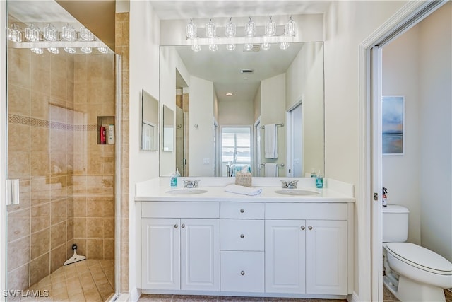 bathroom with vanity, toilet, and a tile shower