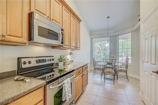 kitchen with pendant lighting, appliances with stainless steel finishes, and light tile patterned flooring