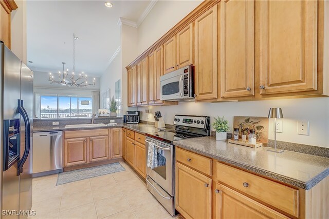 kitchen with sink, appliances with stainless steel finishes, ornamental molding, light tile patterned floors, and an inviting chandelier