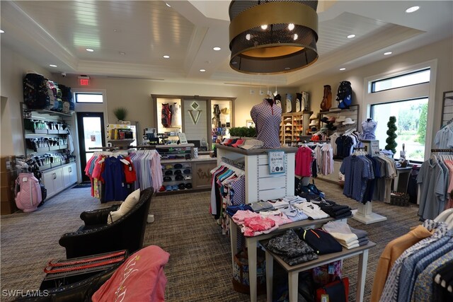 miscellaneous room with a raised ceiling and carpet floors