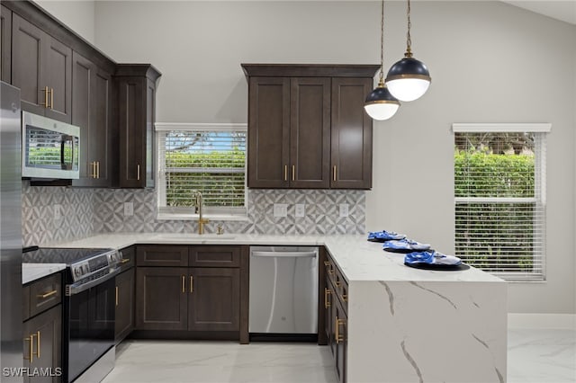 kitchen featuring backsplash, appliances with stainless steel finishes, decorative light fixtures, light stone countertops, and sink