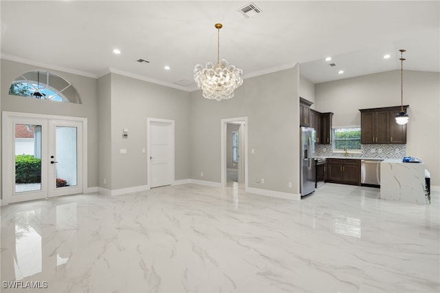 kitchen featuring a towering ceiling, a wealth of natural light, stainless steel appliances, and light stone counters