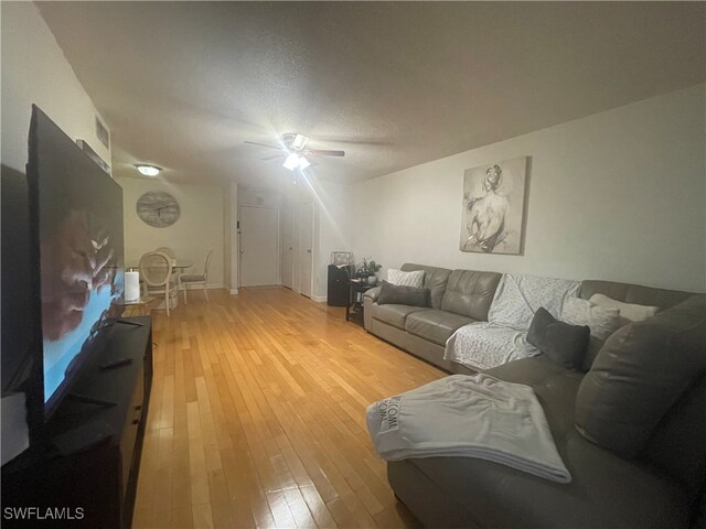 living room featuring hardwood / wood-style floors and ceiling fan