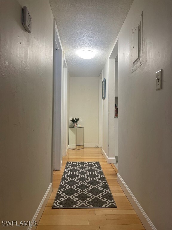 hallway featuring hardwood / wood-style floors and a textured ceiling