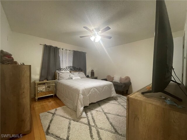 bedroom featuring a textured ceiling, wood-type flooring, and ceiling fan