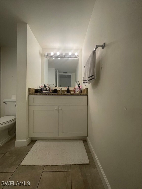 bathroom featuring vanity, toilet, and tile patterned floors