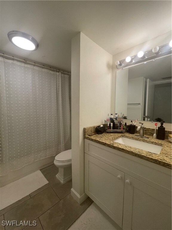 bathroom with vanity, toilet, a shower with curtain, and tile patterned flooring