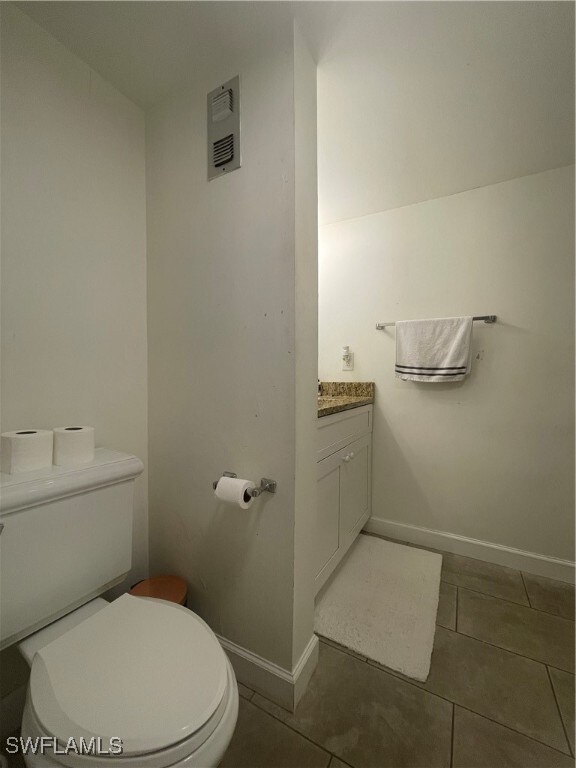 bathroom featuring toilet, vanity, and tile patterned flooring