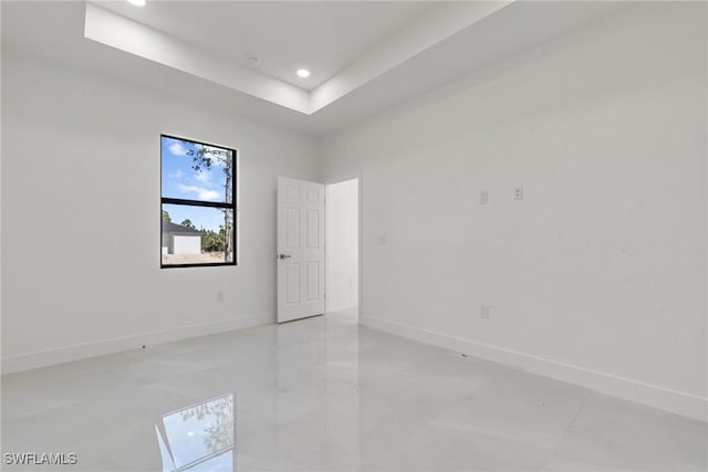 unfurnished room featuring a raised ceiling