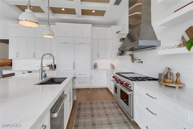 kitchen featuring white cabinets, beam ceiling, extractor fan, appliances with stainless steel finishes, and decorative light fixtures