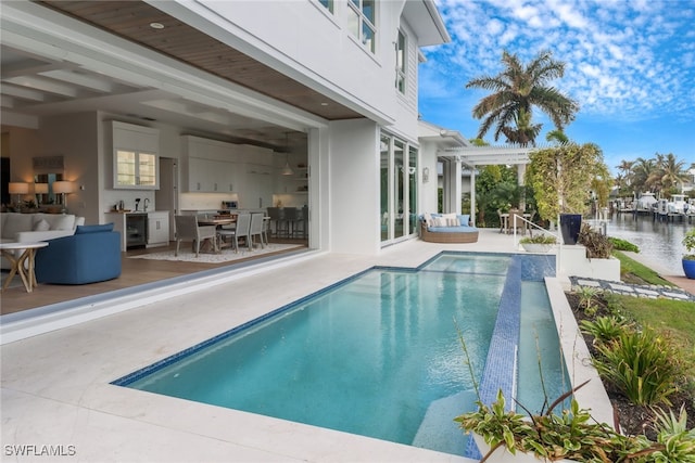 view of pool with a water view, a pergola, and a patio area