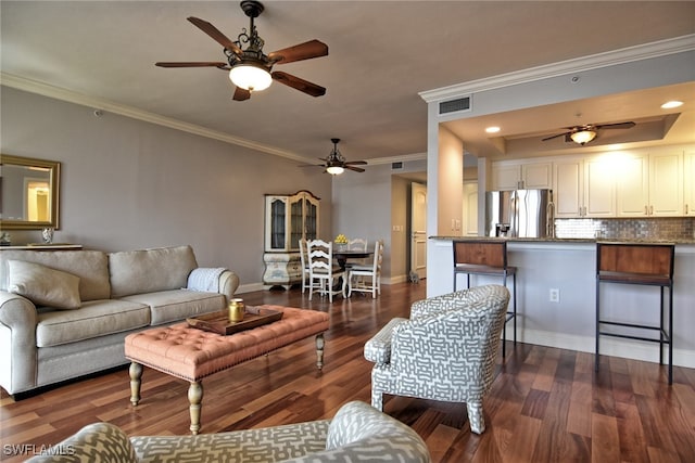 living room with dark hardwood / wood-style floors, ceiling fan, and crown molding