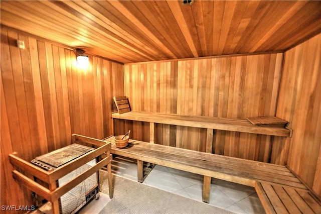 view of sauna featuring tile patterned floors, wood walls, and wood ceiling