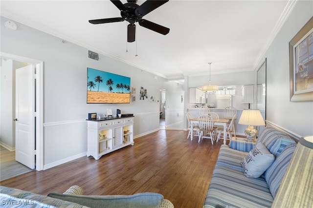 living room featuring crown molding, dark hardwood / wood-style floors, and ceiling fan