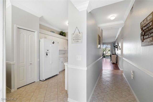 corridor with crown molding and light tile patterned floors