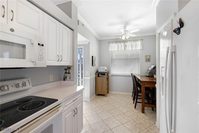 kitchen featuring white appliances, a healthy amount of sunlight, ornamental molding, and white cabinets